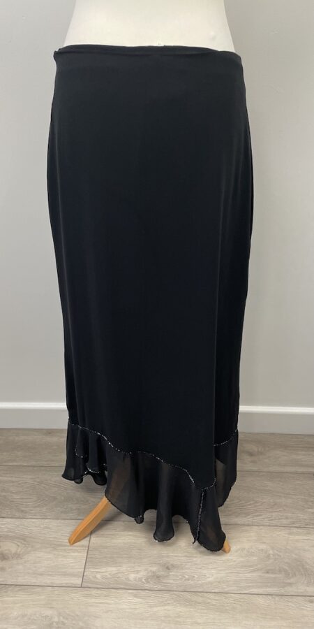 Aide black skirt with side zip. It has a chiffon and beaded assymetric hem